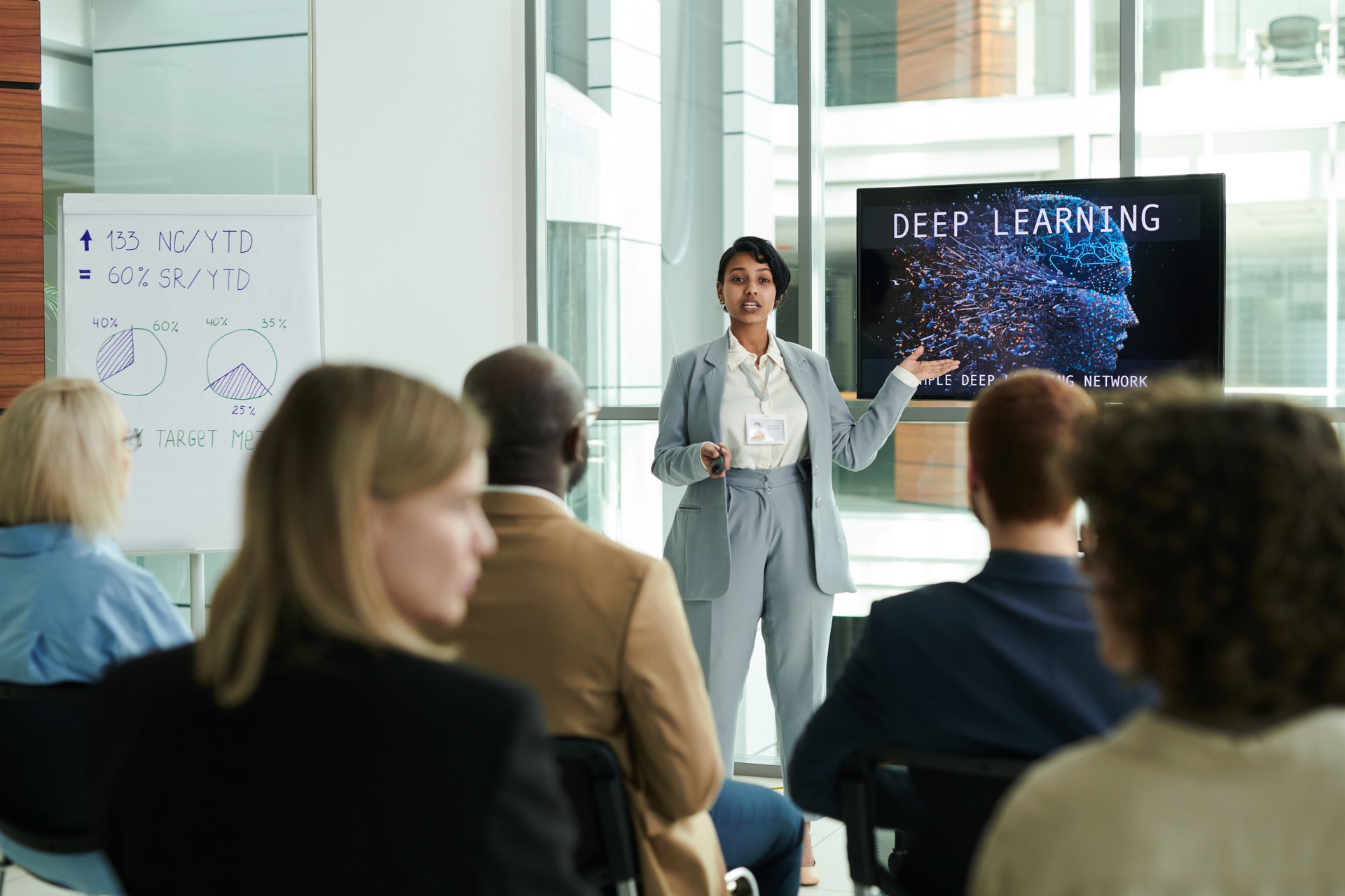 Confident young businesswoman in elegant suit making presentation