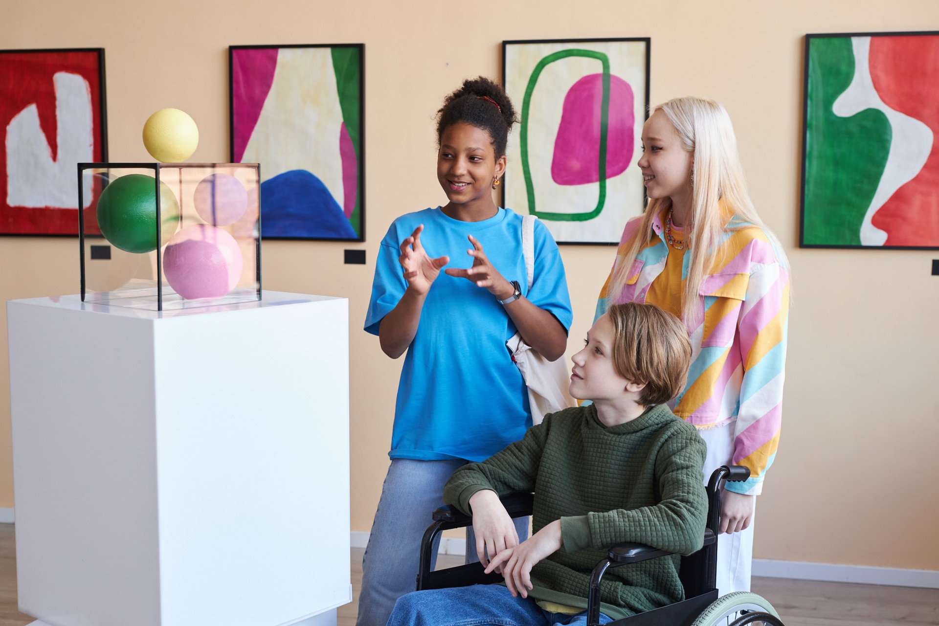 Friends with teen in wheelchair visiting museum together